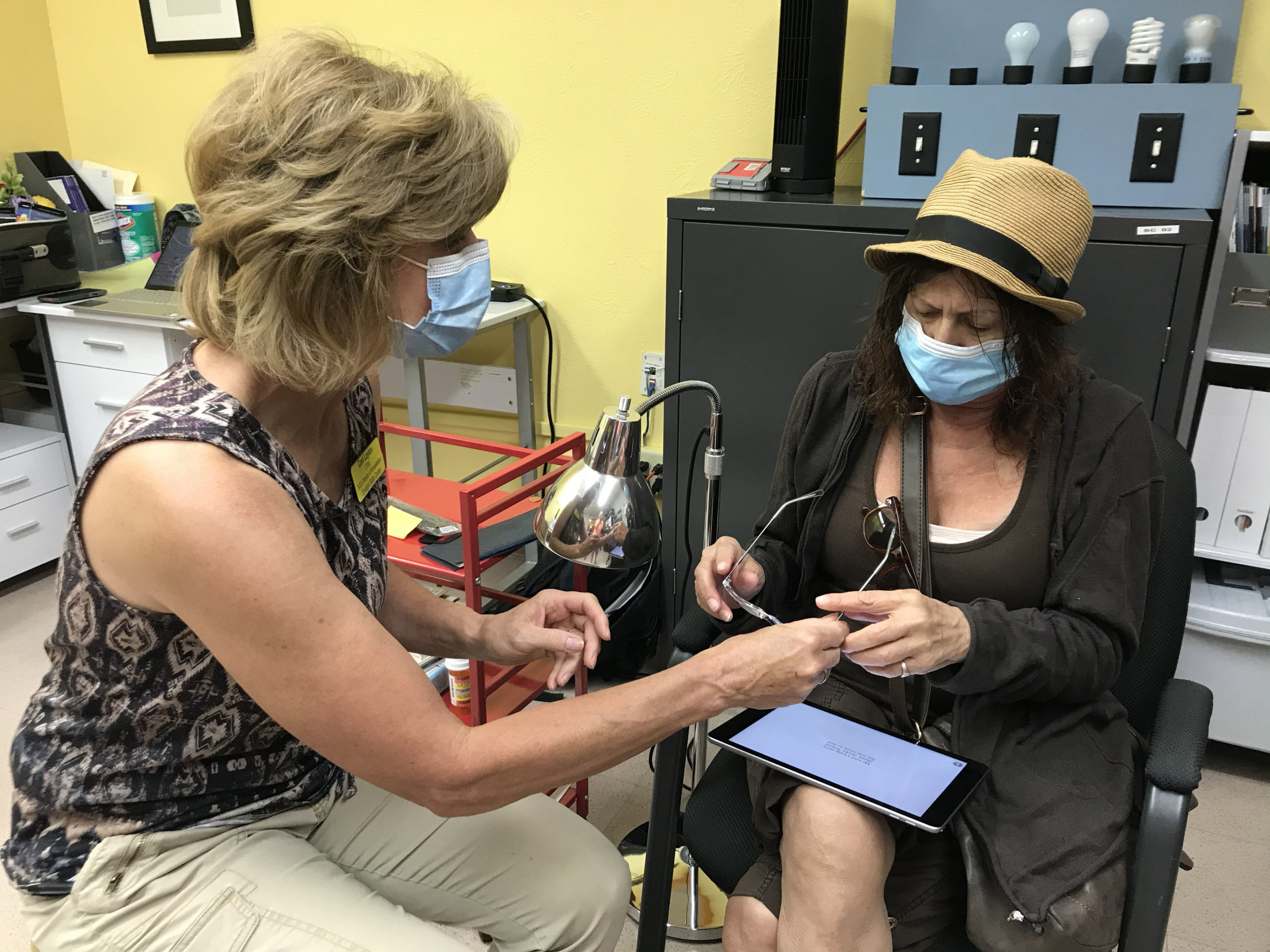Cori Layton of Ensight Skills Center in Fort Collins works with CFI consumer Joyce to help her with tools for dealing with low vision.