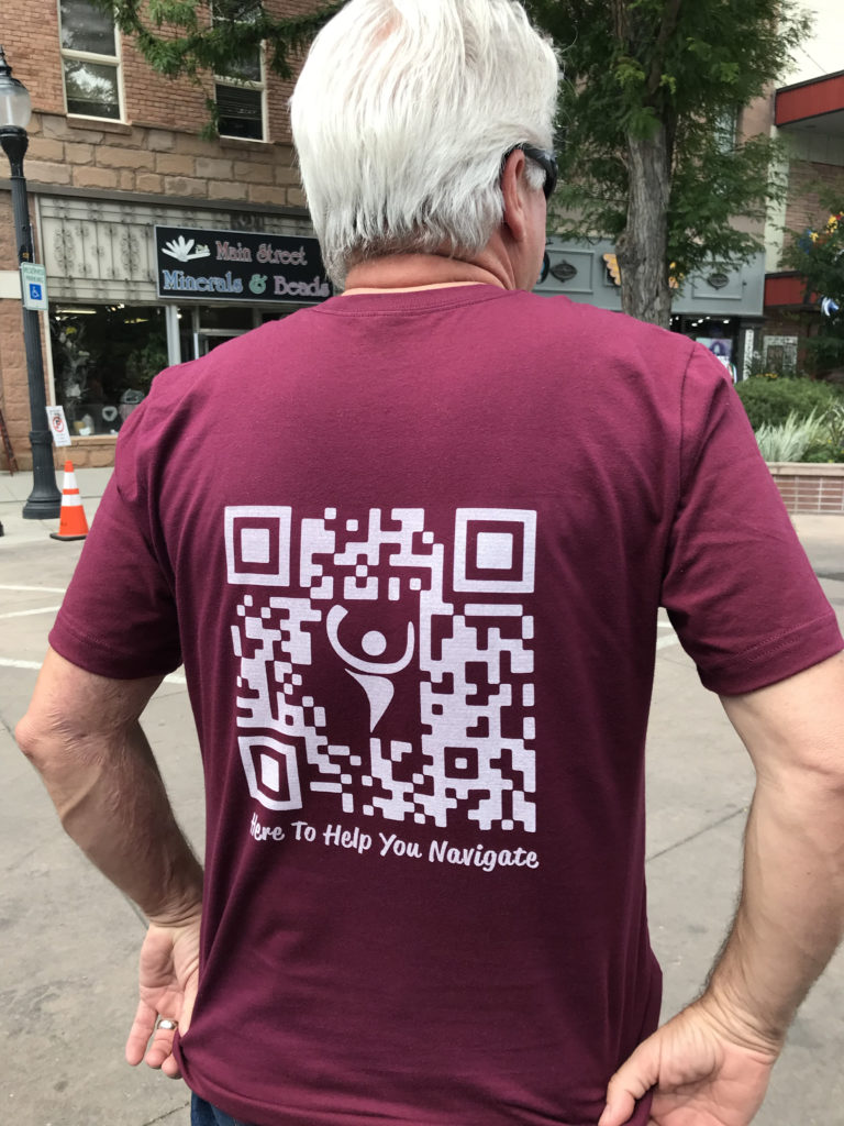 Man standing with back to camera wearing a CFI t-shirt with a CFI QR code on the back.
