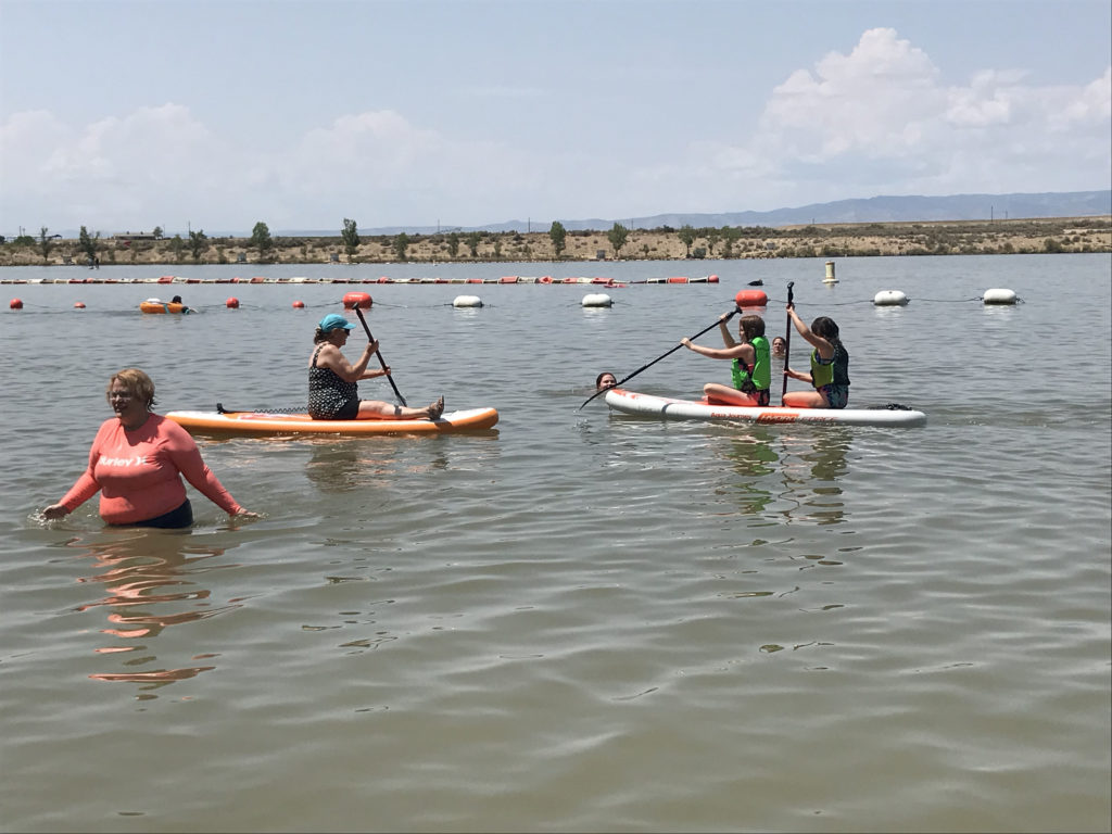 People on paddle boards play in the water. 