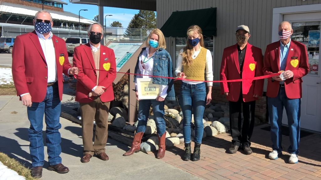 6 people stand together to cut a ribbon in recognition of the new CFI office in Salida, Colorado